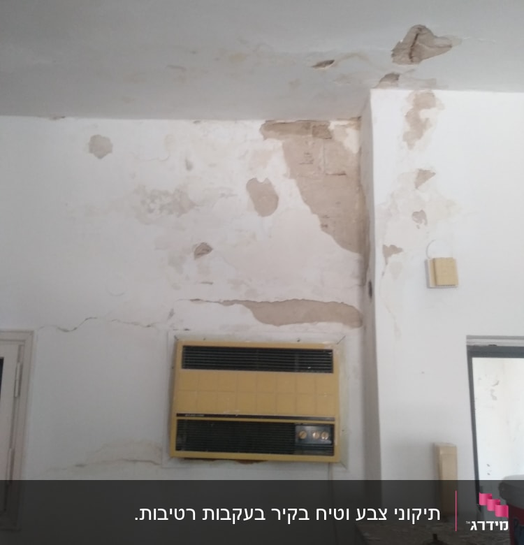 קיר מתקלף עם סימני רטיבות וכלי צביעה על השולחן